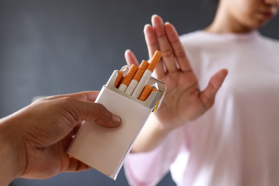 Main qui repousse une cigarette pour symboliser l’arrêt du tabac avec l’hypnose